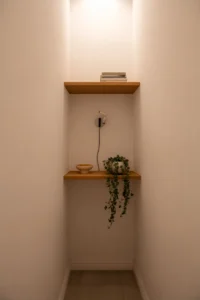 An extremely narrow hallway with two floating wooden shelves