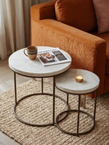 Two marble-look round nesting coffee tables in a small apartment living room