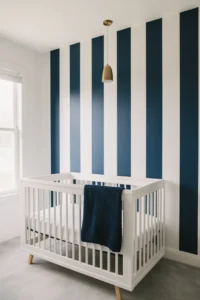 a boy nursery with a bold navy and white vertical stripe painted