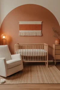 a girl nursery with a matte terracotta painted accent wall