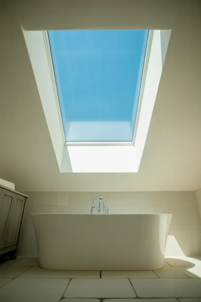 airy bathroom with a large square skylight in the center of a white ceiling
