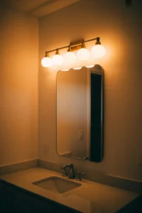 bathroom vanity with a horizontal five-bulb brass bar light mounted