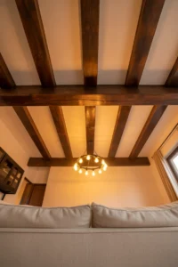 family room with dramatic exposed dark wood ceiling beams against cream painted ceiling