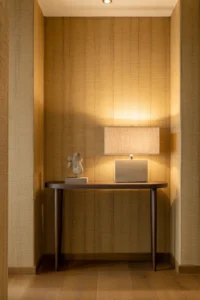 hallway with floor-to-ceiling natural grasscloth wallpaper in a warm golden straw tone