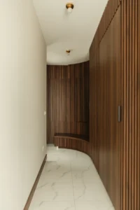 hallway with full-height dark walnut vertical wood slat paneling on one side wall