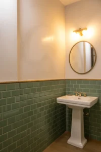 sage green subway tile covering lower two-thirds of bathroom wall