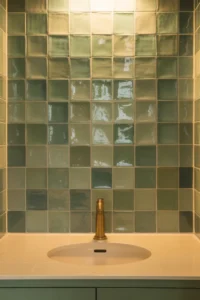 straight-on shot of full vanity wall covered in sage green zellige handmade tile