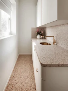 tiny kitchen where the same warm ivory and blush terrazzo flows