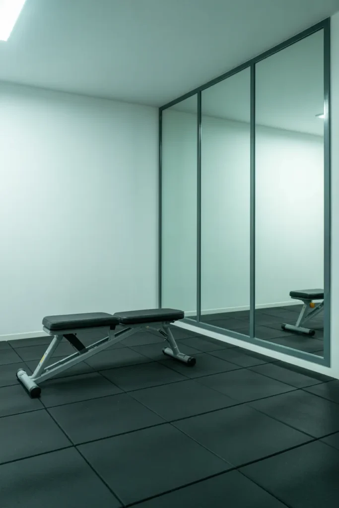 minimal basement gym with dark charcoal rubber floor tiles